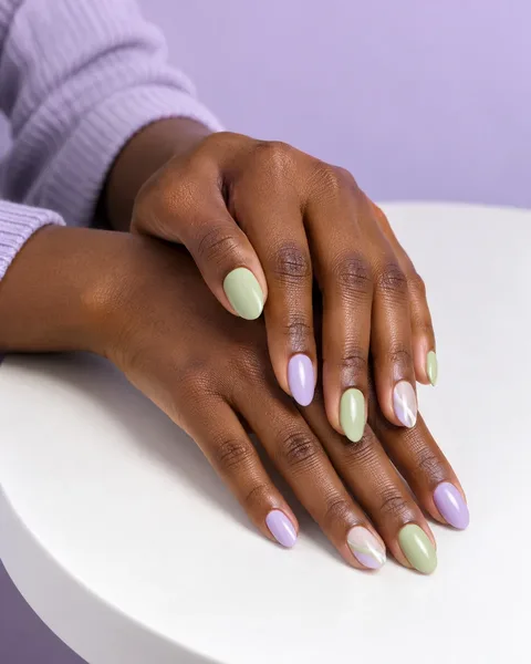 Lavender and matcha green manicure on gently overlapping hands